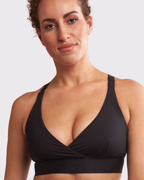 Black / Mastectomy & pocketed wrap sports bra with racerback, back closure and adjustable straps on mastectomy model with breast forms.