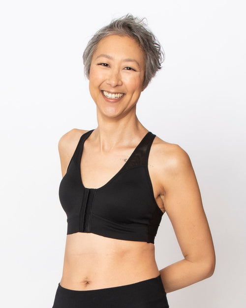 Black / Au Natural & pocketed front closure sports bra with mesh back panel and adjustable straps on au natural model back view