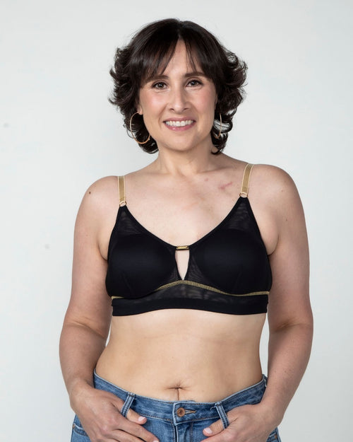 Black / Implants & model wearing the Victoria Pocketed Keyhole bralette with gold lace trim and gold jewel that says anaono