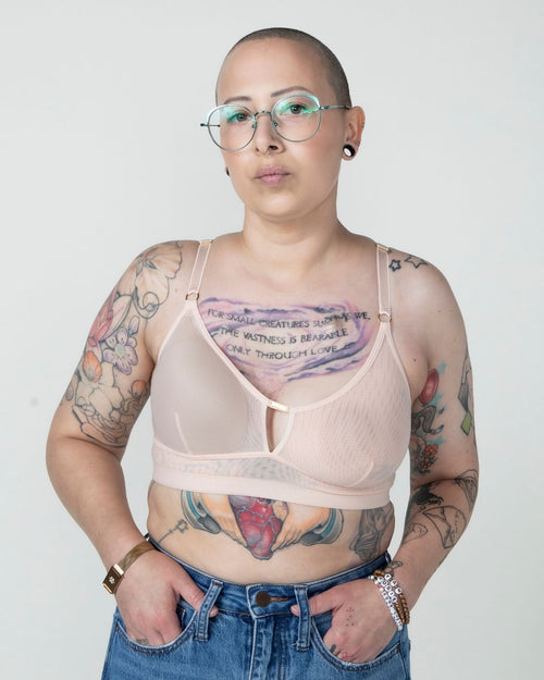Blush / Au Natural & model wearing the Victoria Pocketed Keyhole bralette with gold lace trim and gold jewel that says anaono side view