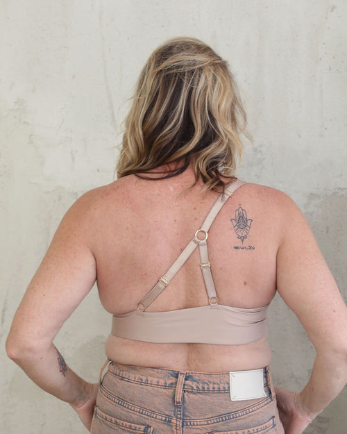 Latte & unilateral sling molded cup bra on unilateral model with one breast on the right side back view