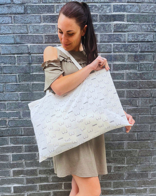 Champagne & anaono exclusive tote bag with new logo and new boob graphics available for limited time only with model holding bag