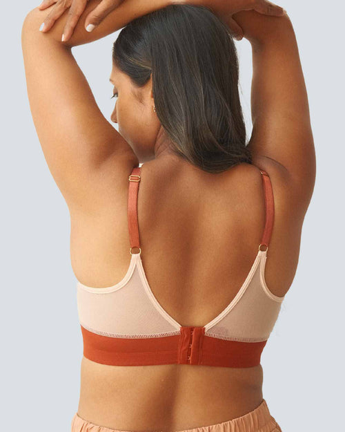 Terracotta / Implants & model wearing the Victoria Pocketed Keyhole bralette with gold lace trim and gold jewel that says anaono